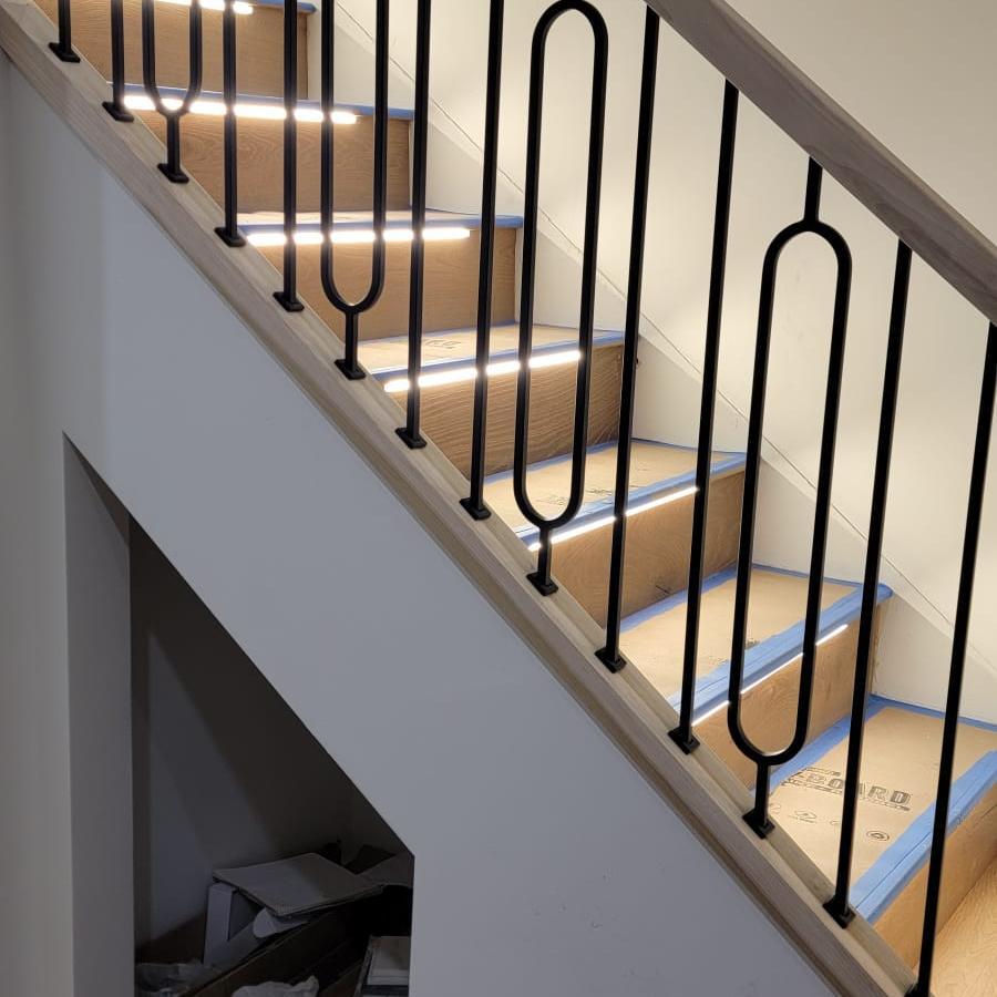 Open-concept stair remodel with modern wood handrail